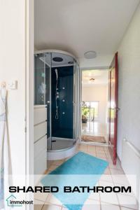 a bathroom with a glass shower with a blue rug at Sunny Home near Zurich Airport in Zürich +44 photos