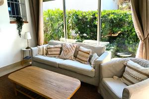 a living room with two couches and a coffee table at Hôtel Le Méditerranée in Hyères