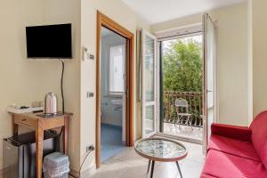 a living room with a red couch and a balcony at Residenza Venezia Amè in Peschiera del Garda