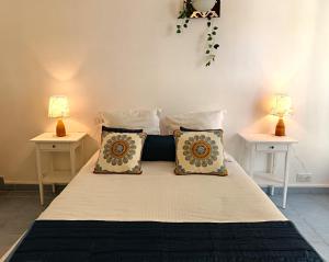 a bedroom with a bed with two lamps on two tables at Hôtel Le Méditerranée in Hyères