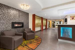 a lobby with two chairs and a fireplace at Days Inn by Wyndham Ottawa in Ottawa
