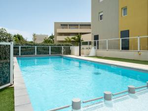 a large blue swimming pool on top of a building at La Dune 32 - Villa 2P4 in Sérignan +10 photos