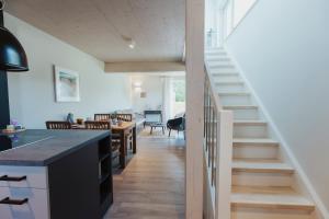 a kitchen and living room with stairs leading to a dining room at NEU "Rügen Resørt Sagard" großzügige, gemütliche Doppelhaushälfte "Dag" mit Terrasse in Sagard +26 photos