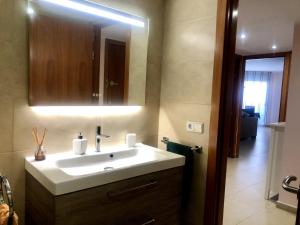 a bathroom with a white sink and a mirror at Vivalidays - Estrella de Mar - Calella in Calella +20 photos