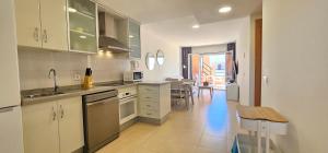 A kitchen or kitchenette at Homes of Spain, Apartamentos Paraíso, Ed Tahiti, Atico A a pie de Playa, piscina privada en solárium, WI-FI