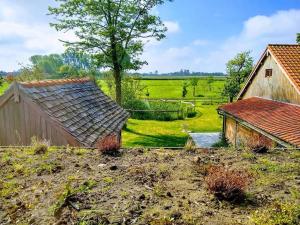 an old barn and a house in a field at den overkant in Diksmuide
