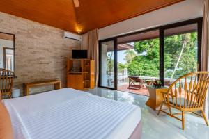 a bedroom with a bed and a large window at Baan Krating Phuket Resort -SHA Plus in Nai Harn Beach