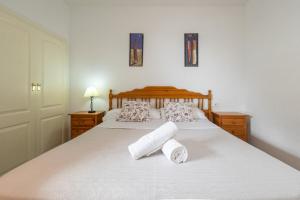 a bedroom with a bed with two rolled towels on it at Zafiro Calpe by Concept Flats in Ifach