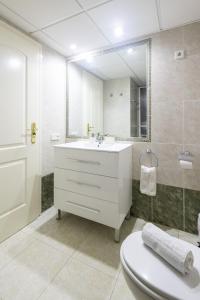a white bathroom with a sink and a mirror at Zafiro Calpe by Concept Flats in Ifach +23 photos