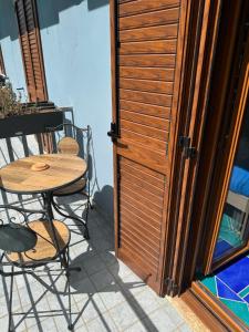 un tavolo e sedie accanto a una porta in legno di Be and Be a Montesano sulla Marcellana