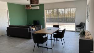 a living room with a table and chairs at Appartement avec terrasse, proche des 1000 étangs, chapelle Le Corbusier in Roye