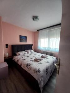 a bedroom with a bed with a floral bedspread at Mountain view apartment in Pirot