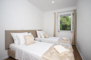 due letti in una stanza con finestra di Villa 3D by the Sea with pool and included breakfast a Kaštela (Castelli) Altre 20 foto