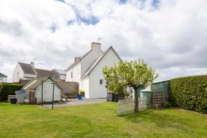 a white house with a fence and a yard at Maisonette face à la mer in Trébérouant