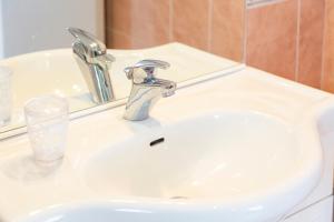 a bathroom sink with a faucet and a glass at Maisonette face à la mer in Trébérouant +18 photos