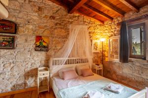a bedroom with a bed in a stone wall at Forest stone Villa with pool in Kriopigi