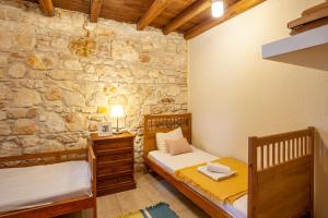 a bedroom with two beds and a stone wall at Forest stone Villa with pool in Kriopigi