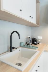 una cocina con fregadero y encimera en Daphni Premium Apartment - Peaceful Veranda Stay in Tinos Old Town, en Tinos