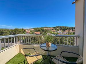 a patio with a table and chairs on a balcony at Studio Emeraude Proche Plage Clim Balcon Dernier Etage Parking - Saint Mandrier Sur Mer - Pin Rolland in Saint-Mandrier-sur-Mer