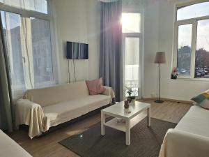 Una sala de estar con un sofá blanco y una mesa. en Midi Gateway, en Bruselas