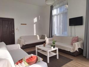ein Wohnzimmer mit 2 weißen Sofas und einem Tisch in der Unterkunft Midi Gateway in Brüssel