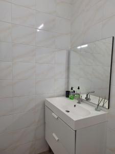 ein weißes Badezimmer mit Waschbecken und Spiegel in der Unterkunft Midi Gateway in Brüssel