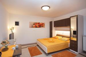 1 dormitorio con 1 cama amarilla grande en una habitación en Apartments Bellistra Labin, en Labin