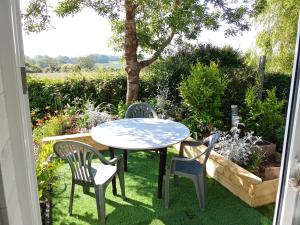 a table and two chairs and a table and chairs at AU PETIT BONHEUR Chez l'habitant 2PERS in Ferques