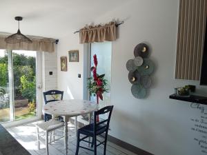 a dining room with a table and two chairs at AU PETIT BONHEUR Chez l'habitant 2PERS in Ferques +3 photos
