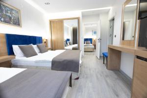 a hotel room with two beds and a television at Ottoman Palace Hotel Edirne in Edirne