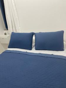 un lit avec deux oreillers bleus dessus dans l'établissement BAHIA FLAT Apt 222, à Salvador 33 autres photos