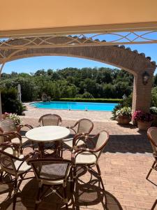 a patio with a table and chairs and a pool at Casale Antica Cassia Beauty Spa in Rome