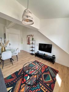 a living room with a television and a table at Soh Rent Appartment 3 Schiltigheim TV Wifi in Schiltigheim