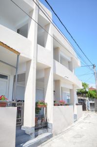 a white apartment building with potted plants on the balconies at NIDA Apartment in Ulcinj