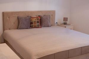 a large bed with a large headboard in a bedroom at NIDA Apartment in Ulcinj