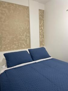 - un lit bleu avec des oreillers bleus dans une chambre dans l'établissement BAHIA FLAT Apt 222, à Salvador