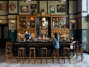 a woman sitting at a bar in a pub at Ace Hotel New Orleans in New Orleans