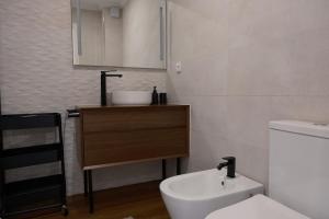 a bathroom with a white toilet and a sink at Refúgio da Barrinha in Praia de Mira