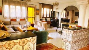 Oulad AkkouNo21 Loulan Villa21号别墅民宿的客厅里有一张沙发和一张桌子。