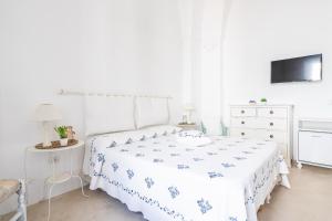 a white bedroom with a bed and a dresser at La dimora del pescatore in Porto Cesareo