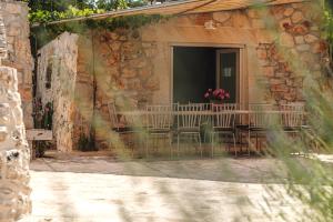 an outdoor patio with chairs and a table with flowers at HelloAPULIA Trulli Flora - Charming Trulli with Private Pool and Garden in Noci