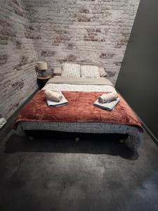 a bed in a room with a brick wall at L'entrepôt in Auxerre