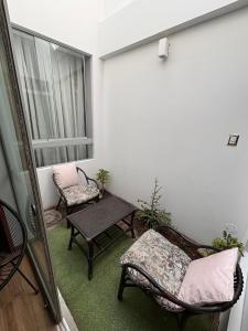 a balcony with two chairs and a table and a window at Ravenala - Apartment Paracas in Paracas