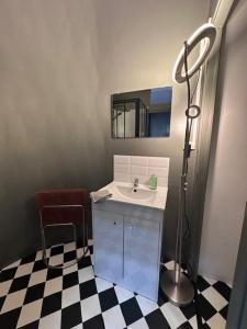 a bathroom with a sink and a mirror and a chair at L'entrepôt in Auxerre