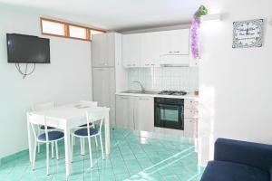 a kitchen with a white table and chairs and a stove at House Of Love in Maiori