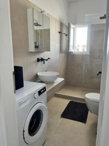 a bathroom with a washing machine and a sink at Aeolian Breeze 3 in Tinos