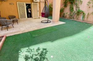 a yard with green grass in front of a building at New Cairo 3BR Villa Garden & Prime Location By Best of Bedz in Cairo