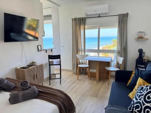 Un dormitorio con una cama y un escritorio con vista al mar. en Beachfront Studio ,The View Calahonda, Panoramic Sea Views, en Mijas Costa