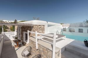 a balcony with a table and chairs next to a swimming pool at Casa Bo Private Pool by Monocle in Vrisi/ Mykonos