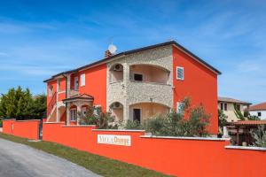 a orange building with a red wall at Apartments Villa Orange in Medulin